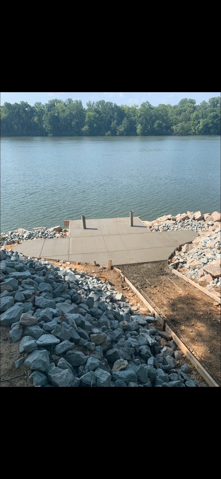 Riverside concrete dock pad with rip-rap stone in Tennessee